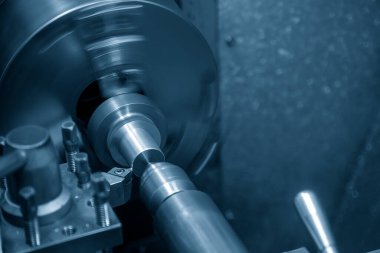 Torna makinesi torna tezgahıyla metal şaft parçalarını kesmiş. Makineyi döndürerek metal işleme süreci.