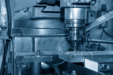 The drilling process on NC milling machine with coolant method. The metal working concept on the milling machine.