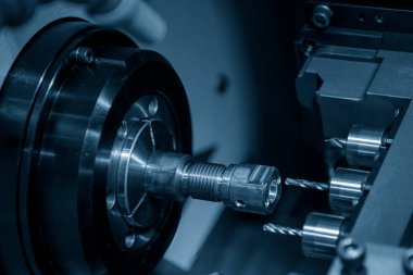 Çoklu görev yapan CNC torna makinesi İsviçre tipi pirinç şaft parçalarını deliyor. CNC dönüşüm makinesiyle çalışan yüksek teknoloji metali.