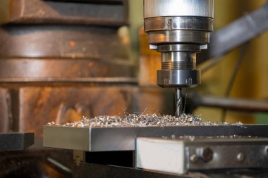 The drilling process on NC milling machine with coolant method. The metal working concept on the milling machine.