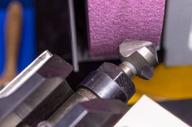 Yakın çekim Chamfer araç öğütme işlemi. Öğütme makinesi ile kesme aracı yeniden öğütme işlemi