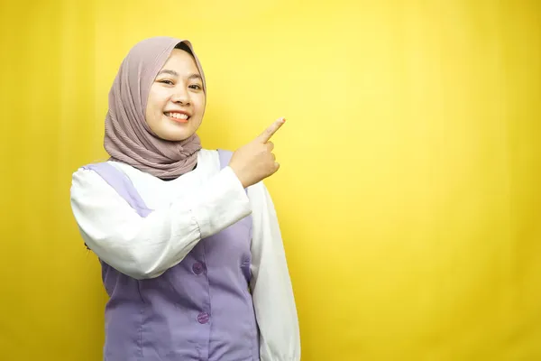 美丽的年轻的亚洲穆斯林女子 手拿着空旷的空间展示什么 面带微笑 看着相机 被黄色背景隔离 广告理念 — 图库照片
