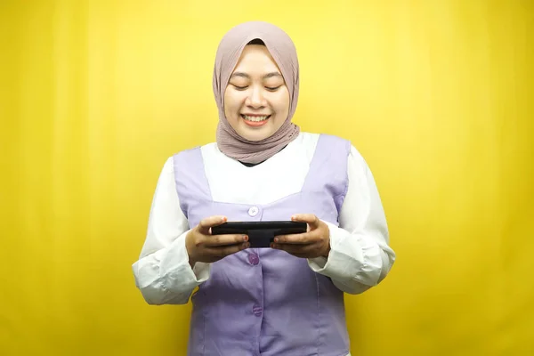 スマートフォンを手に美しいアジアの若いイスラム教徒の女性 ゲームをプレイ 黄色の背景に孤立 広告コンセプト — ストック写真