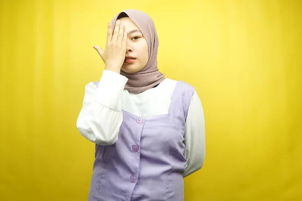 美丽的亚洲年轻的穆斯林女子 一只手捂住一只眼睛 看着被黄色背景隔离的相机 — 图库照片
