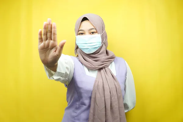 头戴口罩的穆斯林妇女 手持停车标志 拒签手 不要保持距离标志手 不要靠近手签 隔离在黄色背景下 — 图库照片