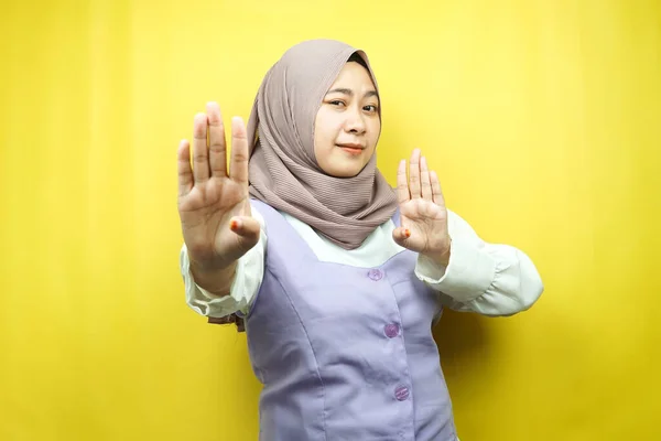 停止記号の手で美しいアジアの若いイスラム教徒の女性は 署名の手を拒否し 禁止記号の手を手に近づくことはありません サインの手を離れて 黄色の背景に隔離されたサインの手を移動しないでください — ストック写真