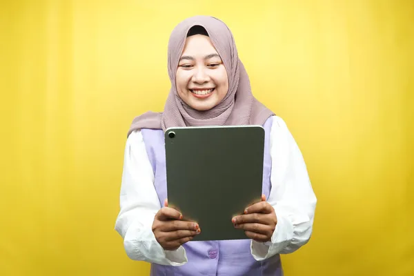 美しい若いアジアのイスラム教徒の女性笑顔 興奮し 陽気な保持タブレット 黄色の背景に隔離されました — ストック写真