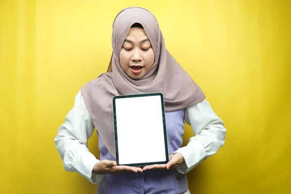 美丽的年轻的亚裔穆斯林女子笑着 兴奋而快乐的手持平板电脑 空白屏幕 促销应用程序 促销产品 展示一些东西 被黄色背景隔离 — 图库照片