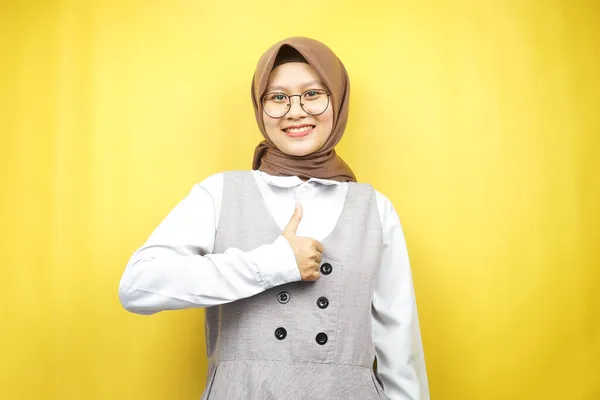 親指を手に美しい若いアジアのイスラム教徒の女性 Okのサイン 良い仕事 お祝い 自信を笑顔 熱狂的で陽気な 黄色の背景に隔離されたカメラを見て 広告コンセプト — ストック写真