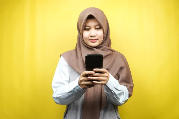 美しいアジアの若いイスラム教徒の女性は黄色の背景に隔離されたスマートフォンを保持 — ストック写真