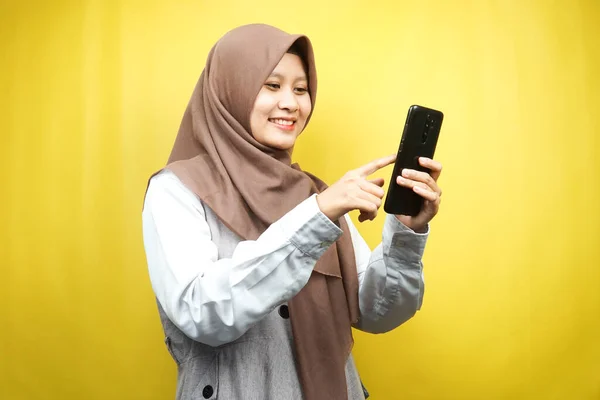 Красивая Молодая Азиатская Мусульманка Улыбается Уверенно Держа Смартфон Изолированным Желтом — стоковое фото