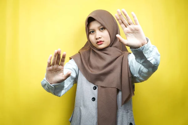 停止記号の手で美しいアジアの若いイスラム教徒の女性は 署名の手を拒否し 禁止記号の手を手に近づくことはありません サインの手を離れて 黄色の背景に隔離されたサインの手を移動しないでください — ストック写真