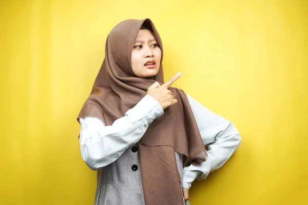 美しい若いアジアのイスラム教徒の女性がショックを受け すごい表現をし 手で空の空間を指して 何かを提示し 製品を提示し 黄色の背景に隔離 — ストック写真