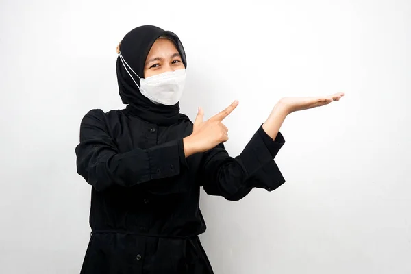 穆斯林妇女自信地微笑着 双手指向空旷的空间 展示某种东西 展示某种产品 被白色背景隔离 — 图库照片