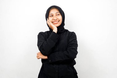 Güzel ve neşeli Asyalı Müslüman kadın, boş alana bakıyor, beyaz arka planda izole edilmiş bir şeyler sunuyor.