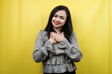 Güzel genç bir kadın, neşeli, elleri göğsünde, soyutlanmış.