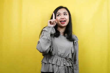 Elleri boş yere bakan güzel genç bir kadın bir şeyler sunuyor, ürünleri tanıtıyor, fikirler üretiyor, reklam yapıyor, izole ediyor.