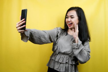 Güzel genç bir kadın video çekiyor, selfie çekiyor, birini arıyor, reklam yapıyor, izole edilmiş.