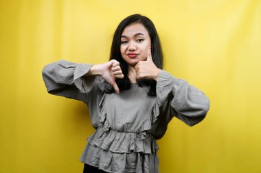 Elleri hoşlanan ya da hoşlanmayan güzel genç bir kadın, evet ya da hayır, mutlu ya da üzgün, iki şeyi kıyaslıyor, reklam, izole edilmiş.