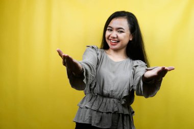 Güzel, genç bir kadın, kollarını açmış, hoş geldin, mutlu, izole bir şey sunuyor.