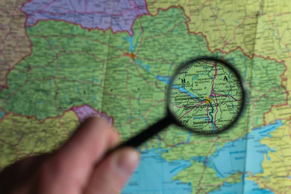 War in Ukraine. Look at map with magnifying glass close up. Ukrainian language map