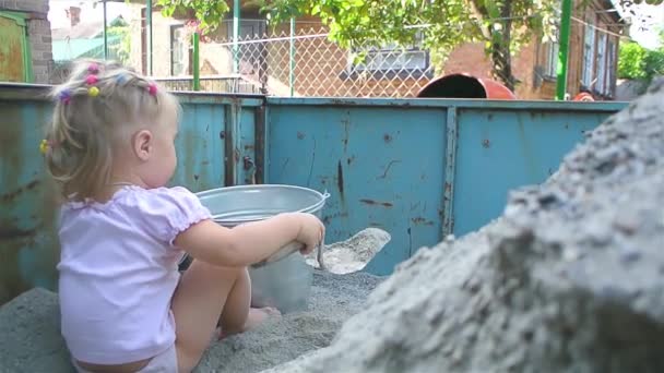 Holčička pomáhá stavět dům: nalévat sutiny do betonového mixéru — Stock video