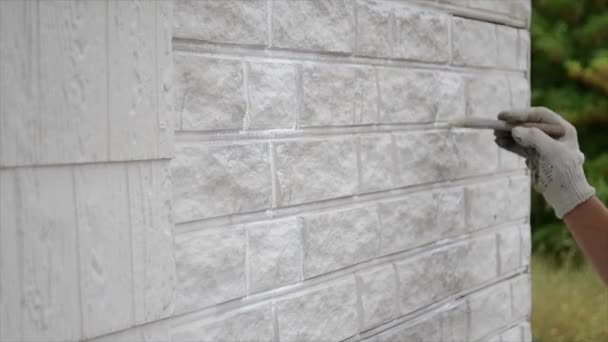 Строитель очищает изоляционные листы на стене фасада дома — стоковое видео
