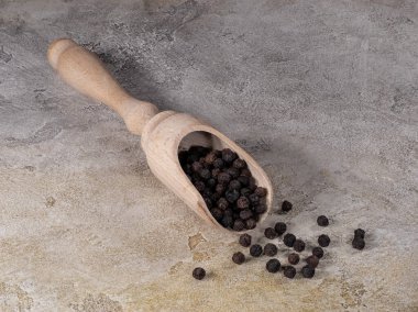 Baharatlar için ahşap kürekte siyah biber.