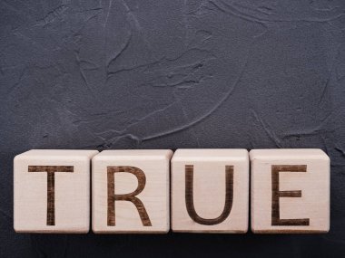 Gri beton arkaplanda tahta küpler üzerine metin Gerçekliği