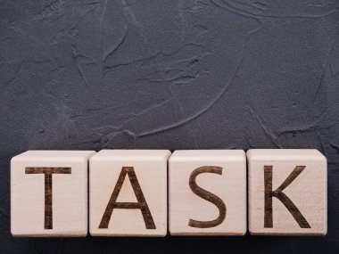 Gri beton arka planda tahta küplerle ilgili kelime TASK