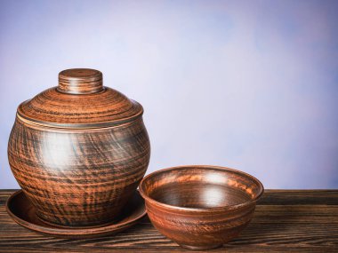 Seramik kahverengi tencere ve boş bir kase.