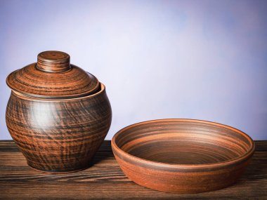 Kahverengi kil çömlek boş tabakla ahşap masada