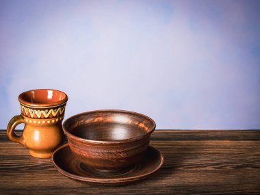 Boş bir kase ve bir fincan, tahta bir masanın üzerinde duruyor.