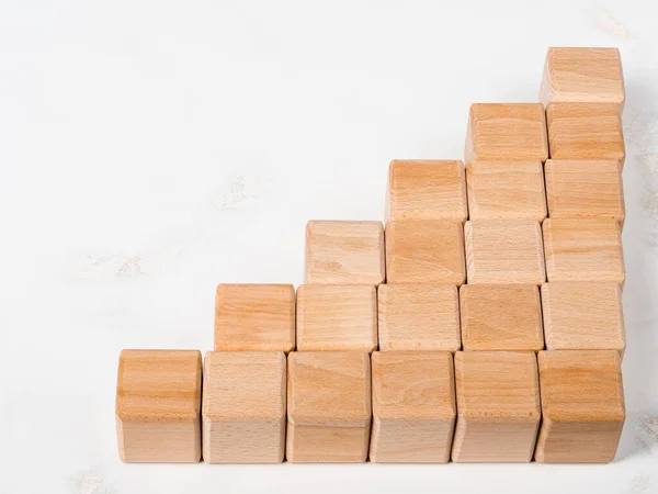 Stack of wood blocks in graph shape as metaphor to business rising