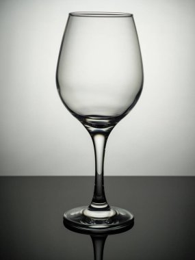 Gri bir yüzeyde boş bir şarap kadehi duruyor.