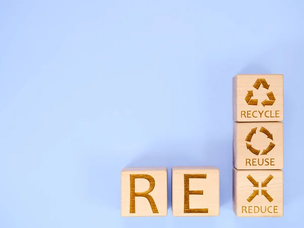 REDUCE, REUSE, RECYCLE as concept symbols is written on wooden cubes
