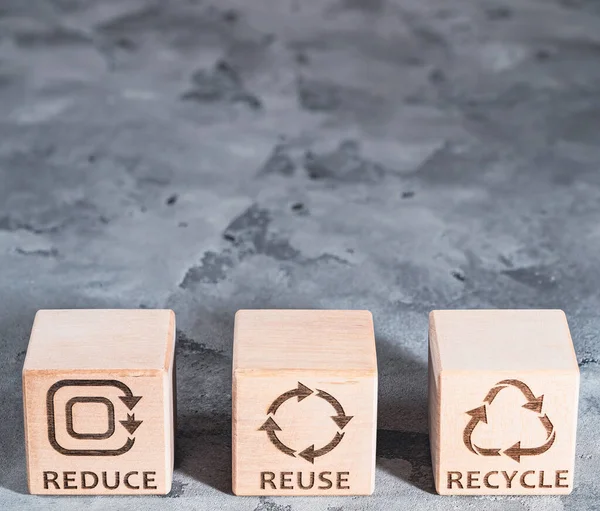 REDUCE, REUSE and RECYCLE on wooden cubes as environmental conservation and renewable resource concept