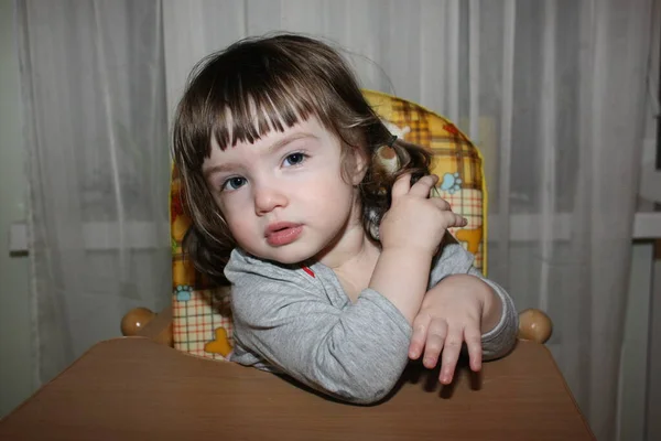 Yüksek sandalyedeki sevimli küçük kız.