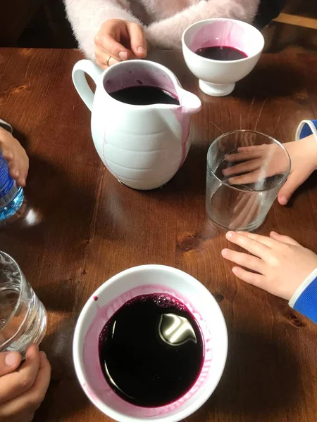 子供を持つ家族はテーブルの周りで一緒に飲む 大人用のワインと子供用の水がテーブルで提供されています 他の人と食事の前に飲み物を共有することは 品質の時間の最良の形態です — ストック写真