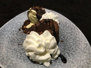 Çikolatalı pasta ya da çikolatalı kremalı ve dondurmalı, koyu arka planda, yakın plan. Lezzetli tatlılar ve tatlı