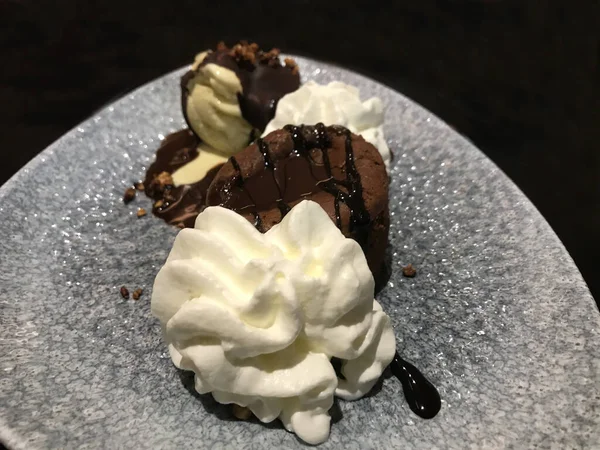 Çikolatalı pasta ya da çikolatalı kremalı ve dondurmalı, koyu arka planda, yakın plan. Lezzetli tatlılar ve tatlı