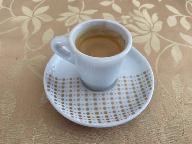 Espresso Coffee served on a beautiful cup with brown design. Brown design table in the background