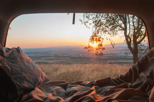 Sunset seen from the back of a camper with amazing landscape. Adventure trip with amazing feeling. Concept of nature and having freedom in holiday
