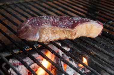 Wide salted beef steak on the grill with flames. Spanish style. Barbacue. bbq. Party, family or celebration event concept