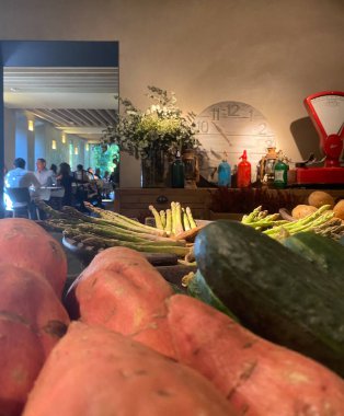 Ortaçağ tavernası restoranı. Zamanının sebzeleri ve antika aletleri var. İnsanlar yemek yiyor..