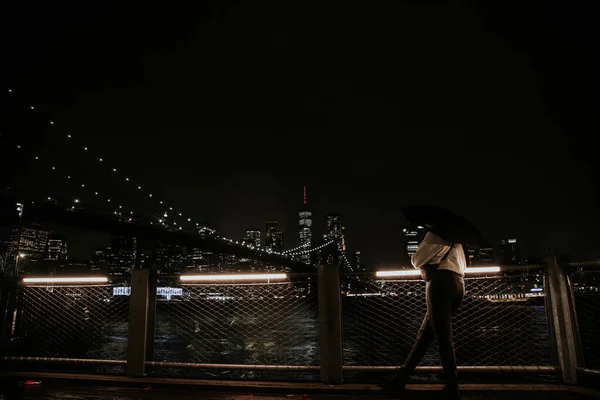 Ragazza guardando il ponte di Brooklyn sotto la pioggia — Foto Stock