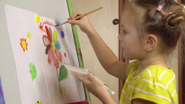 Portrét malé krásné dívky, která kreslí s barvami na lehkách.Školka, lekce malování. — Stock video