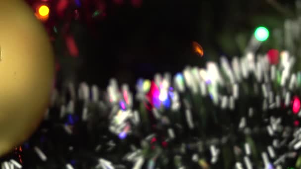 Arka plan bulanık. Çelengin renkli ışıkları Noel ağacında yanıp sönüyor. Yeni yıl.. — Stok video