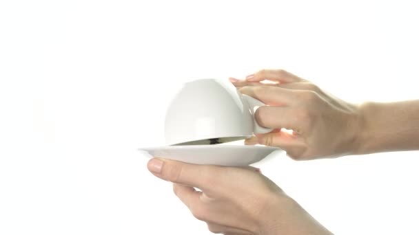 Женские руки переворачивают белую чашку, внутри которой кофейные гущи имеют форму сердца. Крупный план — стоковое видео