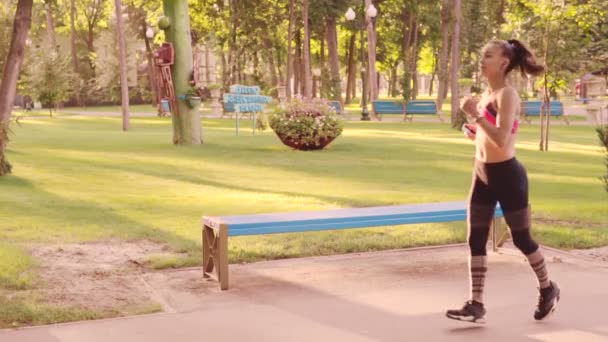 Krásná mladá dívka jogging v parku, zpomalený film. Ranní běhání v opuštěném parku. — Stock video